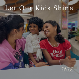 A women and two children sitting together with text 'Let Our Kids Shine' and logo 'avee'.